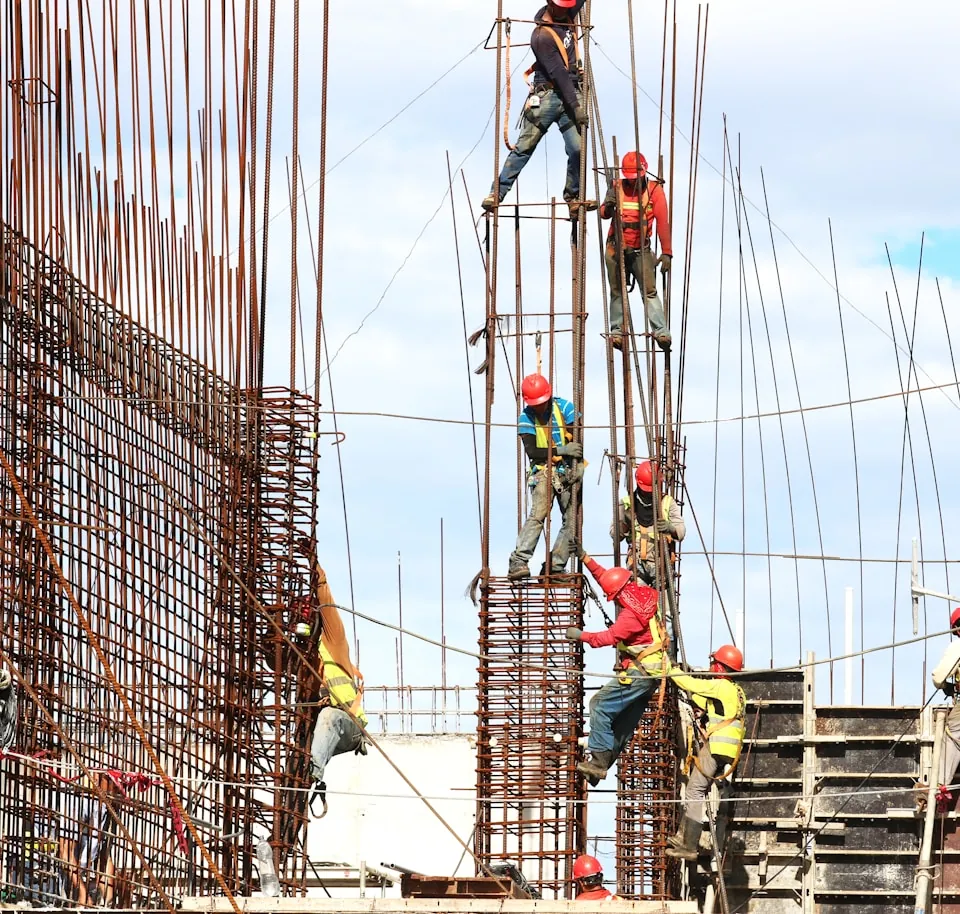 Workers in hard hats tying steel reinforcement on a building site