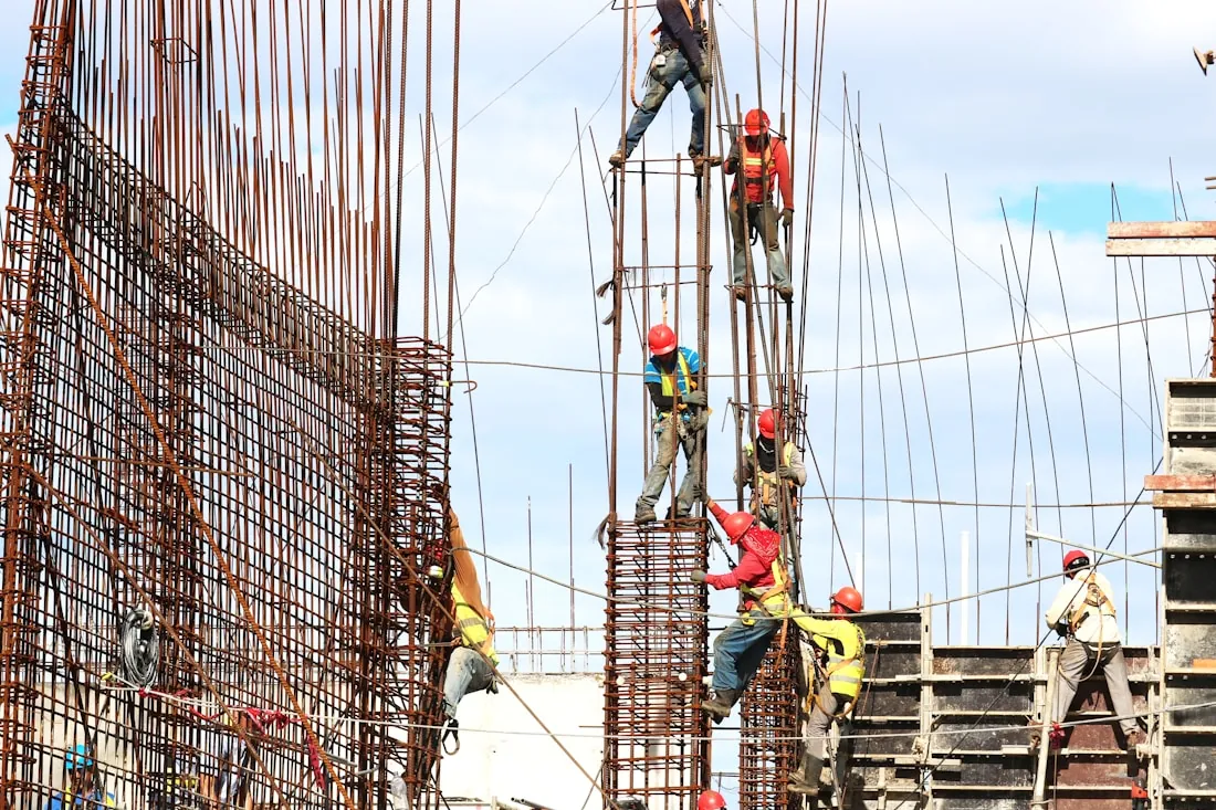 Workers in hard hats tying steel reinforcement on a building site