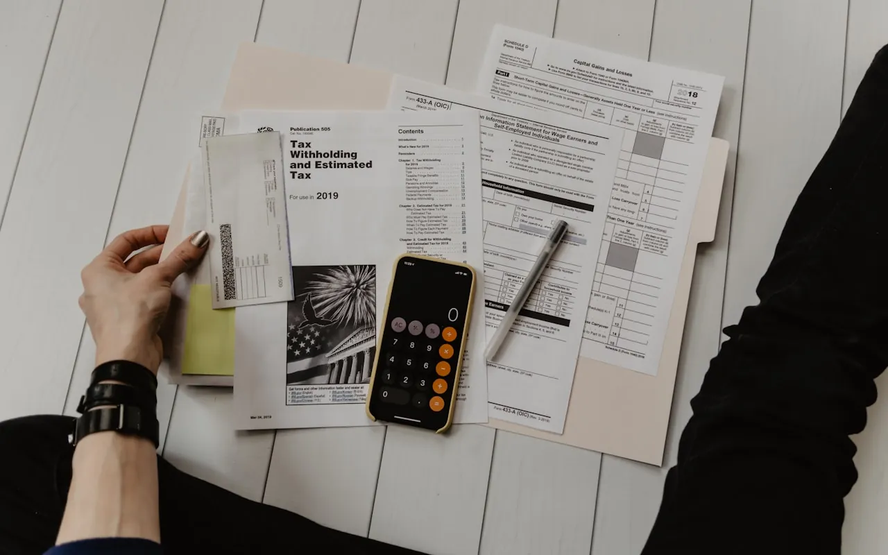 Paperwork and a calculator spread across a desk, worked through by hand