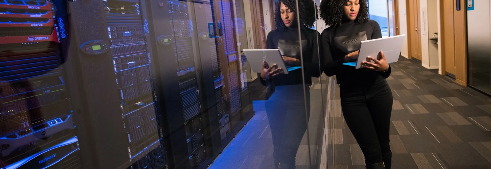 Two engineers reviewing systems on tablets inside a data centre