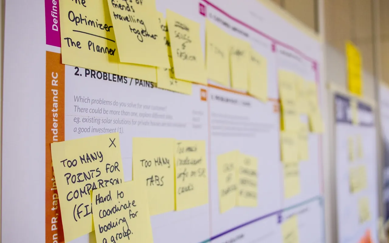 A research wall of handwritten sticky notes recording user problems