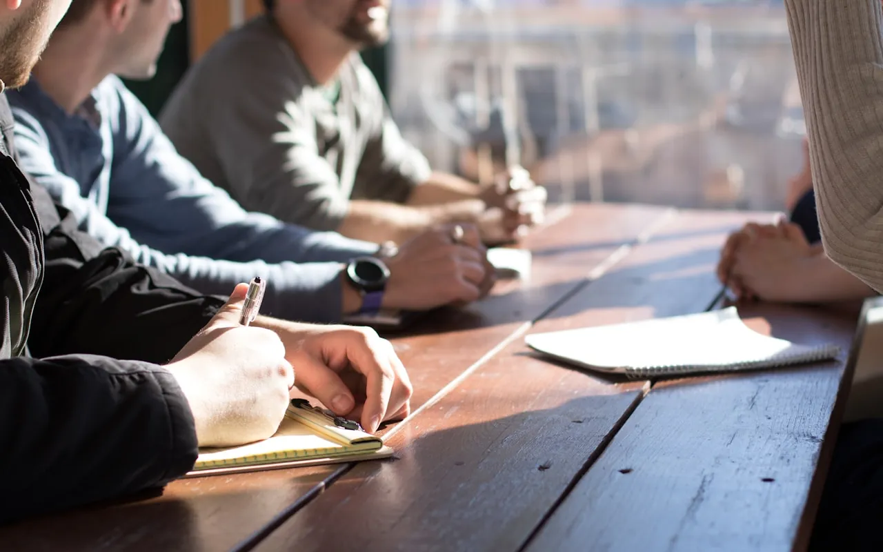 People around a table taking notes during a review session