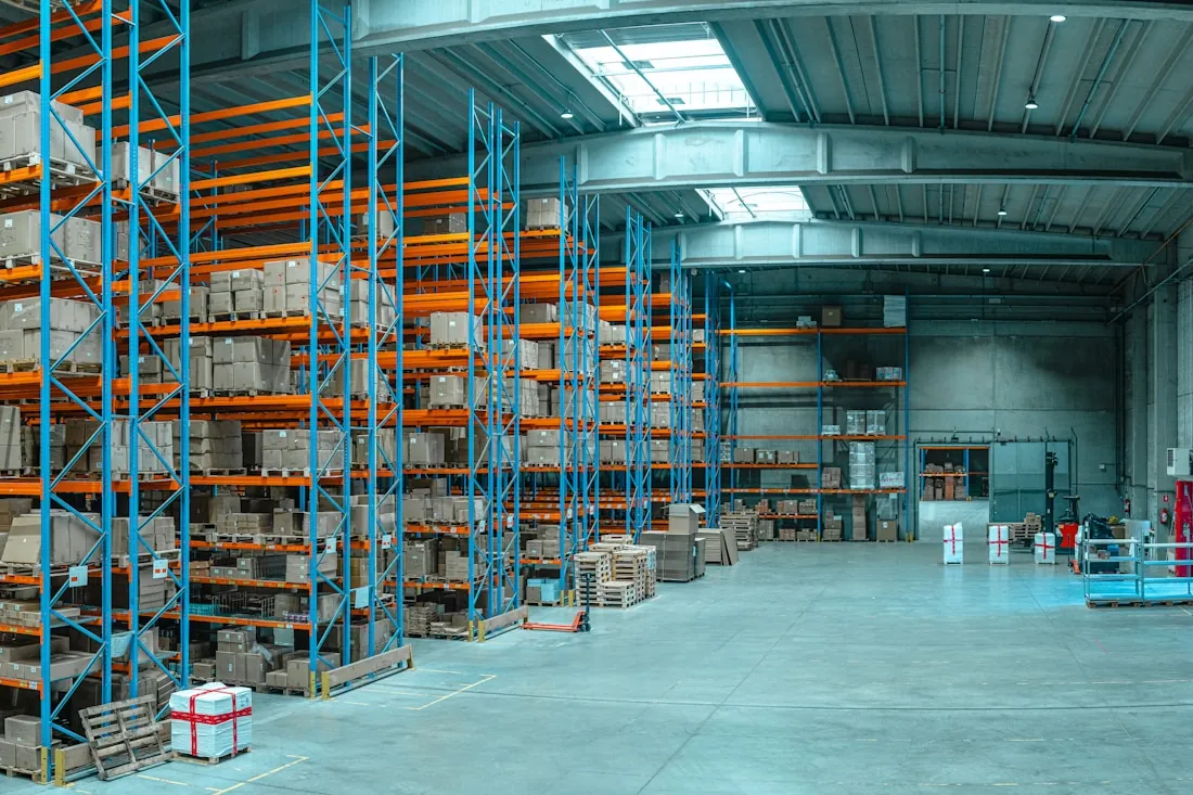 Pallet racking stacked with goods along a distribution centre aisle