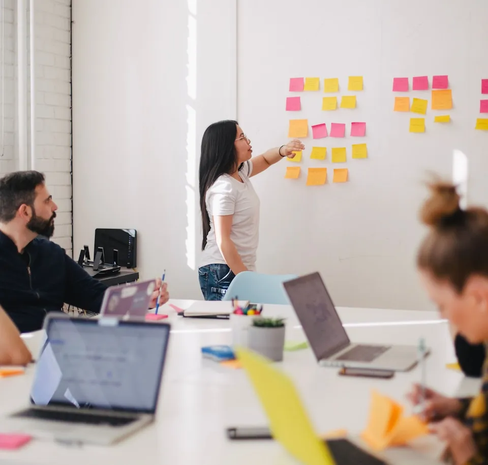 A team mapping work across a wall of notes in a studio