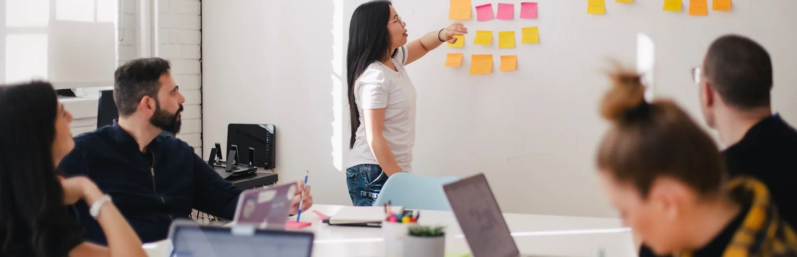 A team mapping work across a wall of notes in a studio