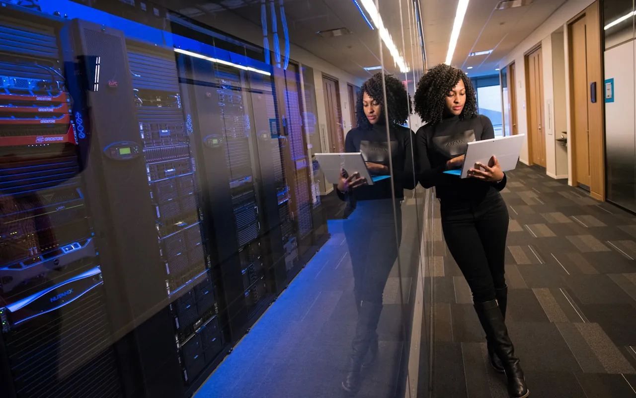 Two engineers reviewing systems on tablets inside a data centre